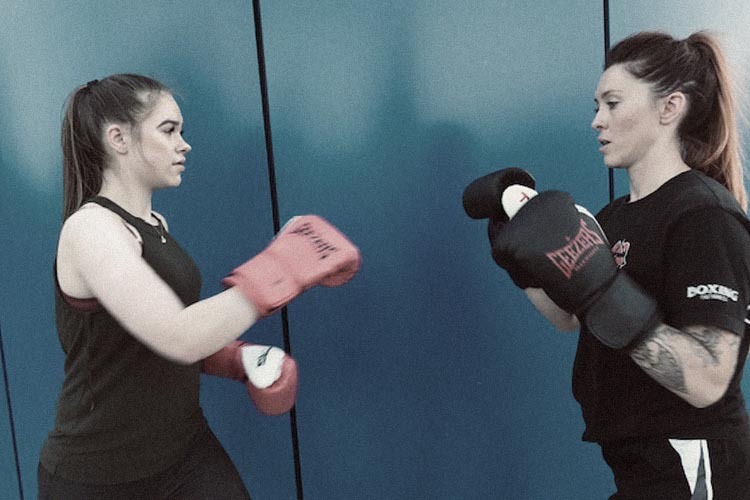 Young women using boxing pads at Sisters-Through-Boxing training session